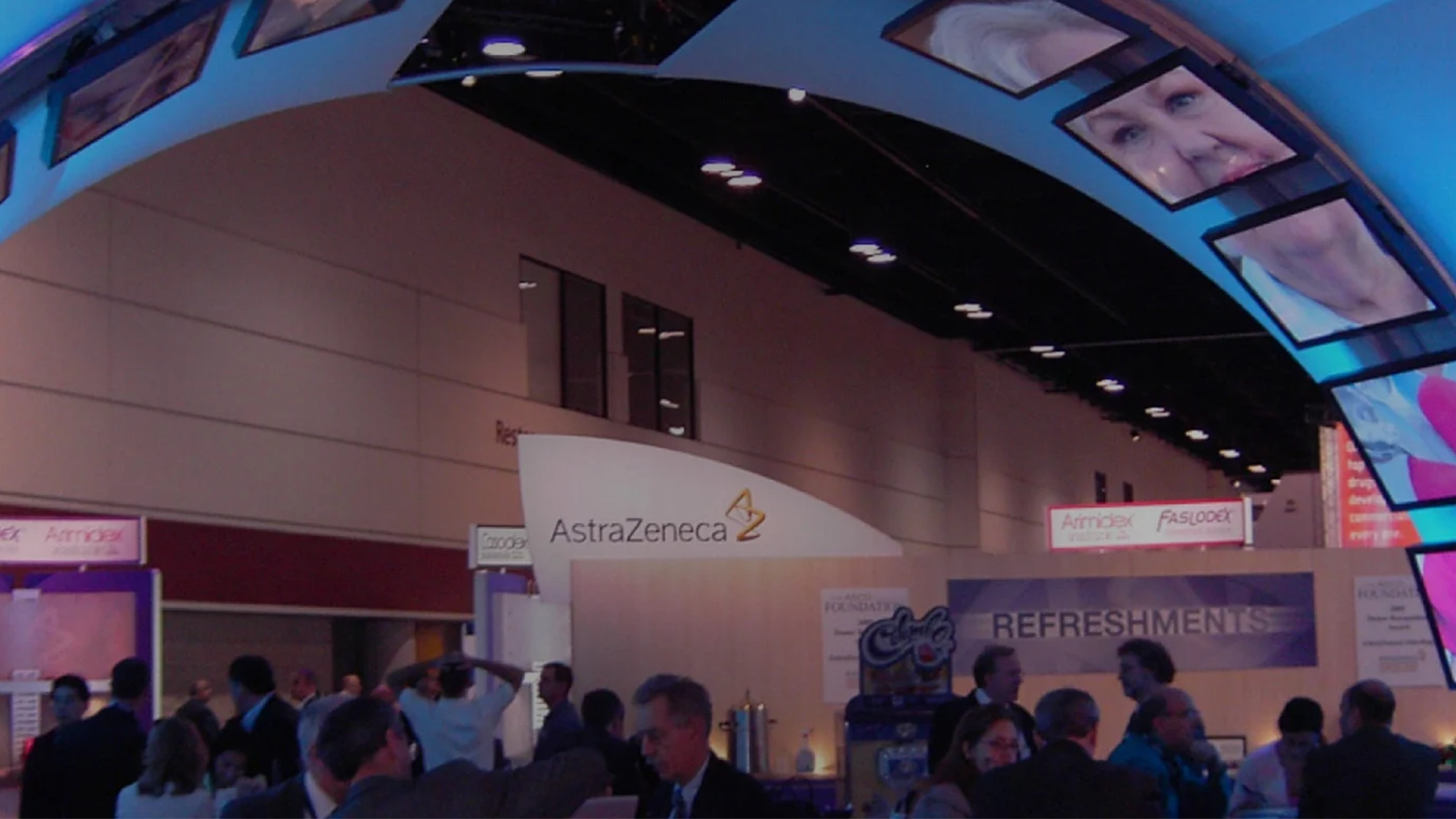 an image of a tradeshow. there are many people around and there is a large blue arch